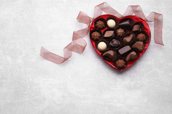 心形盒子 有美味的巧克力糖果和带在浅灰色的桌子上 案文的篇幅 — 图库照片