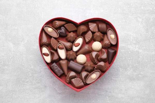 Caixa Forma Coração Com Deliciosos Doces Chocolate Mesa Cinza Claro — Fotografia de Stock