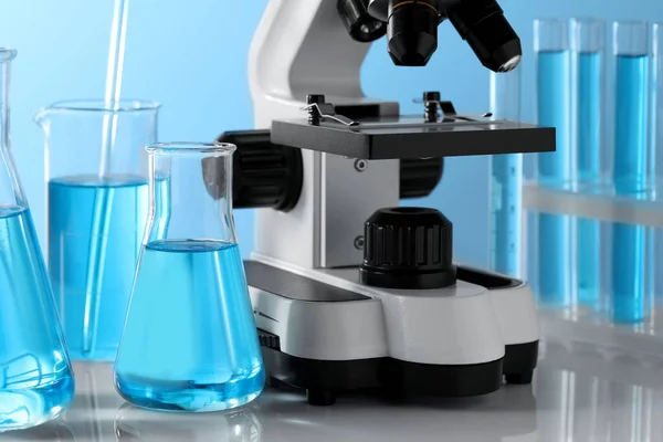 Different Laboratory Glassware Test Tubes Light Blue Liquid Microscope Table — Stock Photo, Image