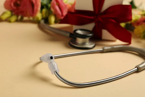 Stethoscope Ajándékdoboz Virágok Bézs Háttérrel Közelkép Szöveggel Boldog Orvosnapot — Stock Fotó