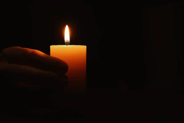 stock image Woman holding burning candle in hand on black background, closeup. Space for text