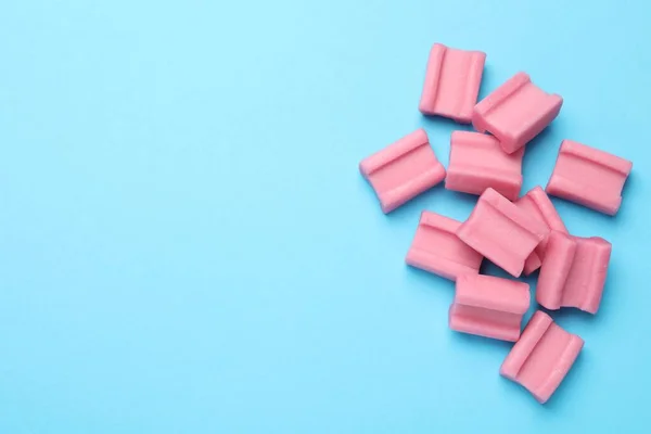 浅蓝色的背景上 有淡淡的粉红咀嚼口香糖 案文的篇幅 — 图库照片