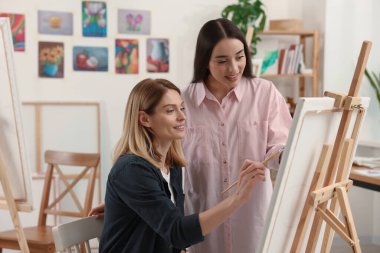 Sanatçı öğrencisine stüdyoda resim yapmayı öğretiyor. Yaratıcı hobi