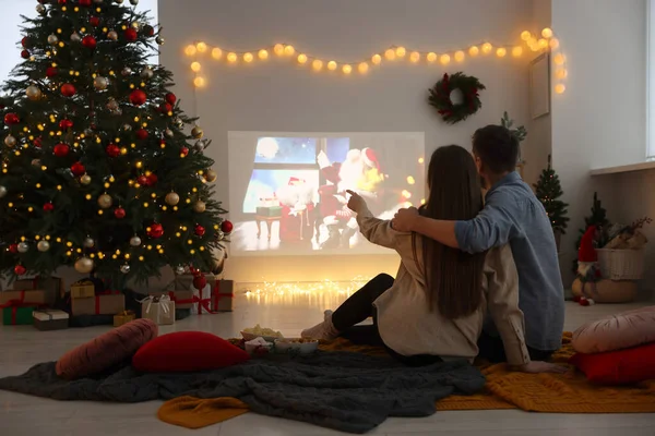 居心地の良い部屋 バックビューでビデオプロジェクターを介してクリスマス映画を見てカップル 冬の休日の雰囲気 — ストック写真