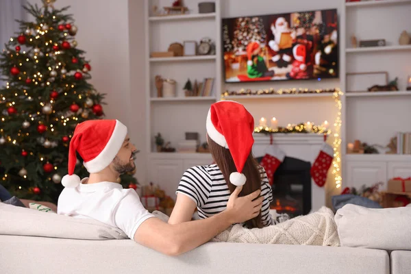 Szczęśliwa Para Ogląda Świąteczny Film Przez Przytulnym Pokoju Widok Tyłu — Zdjęcie stockowe