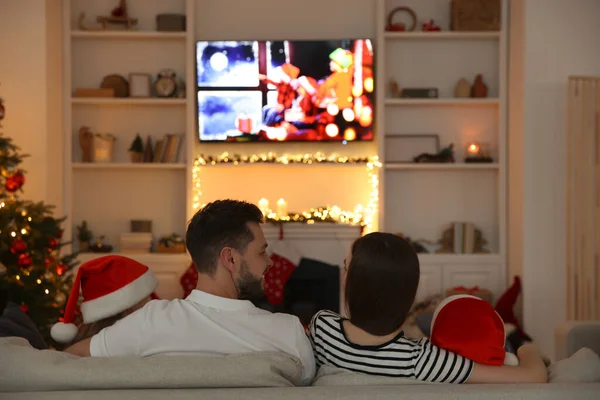 幸せな家族は居心地の良い部屋 バックビューでテレビの近くのソファで時間を過ごす クリスマスの雰囲気 — ストック写真