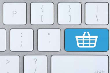 Çevrimiçi alışveriş. Bilgisayar klavyesinde alışveriş sepeti olan açık mavi düğme, üst görünüm