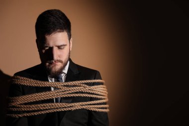 Adam bağlandı ve karanlık arka planda rehin alındı. Metin için boşluk