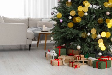 Güzel paketlenmiş hediye kutuları, oturma odasındaki Noel ağacının altında ahşap kızak ve fener.