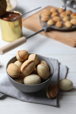 Lezzetli ceviz şekilli kurabiyeler. Yoğunlaştırılmış süt beyaz ahşap masa üzerinde.