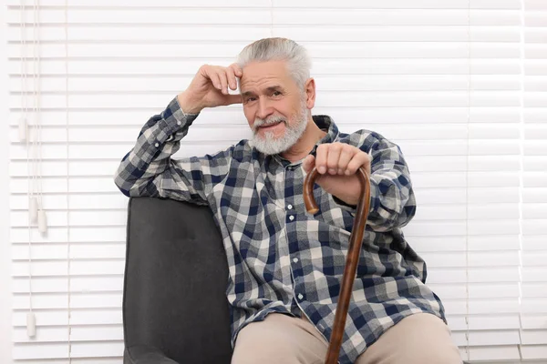 老年人 拿着手杖坐在家里的扶手椅上 — 图库照片