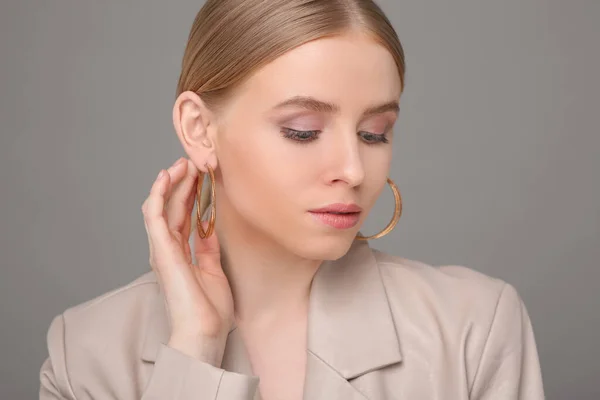 stock image Beautiful young woman with elegant earrings on gray background