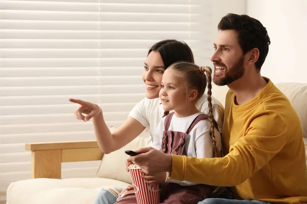 幸せな家族はソファの上にポップコーンとテレビを見て屋内 テキストのためのスペース — ストック写真