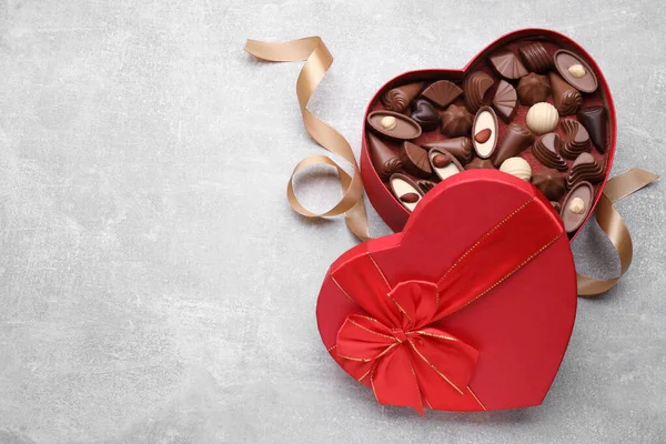 Herzförmige Schachtel Mit Leckeren Schokoladenbonbons Und Schleife Auf Hellgrauem Tisch — Stockfoto