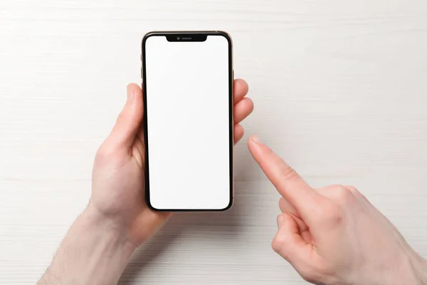 Mann Hält Smartphone Mit Leerem Bildschirm Weißem Holztisch Draufsicht Mockup — Stockfoto
