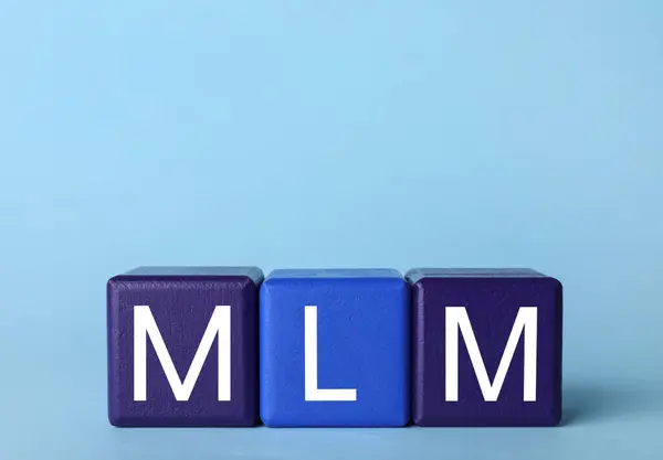 stock image Multi-level marketing. Abbreviation MLM of cubes with letters on light blue background