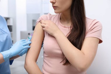 Doktor klinikteki hastaya hepatit aşısı veriyor.