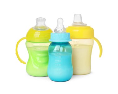 Feeding bottles with milk on white background