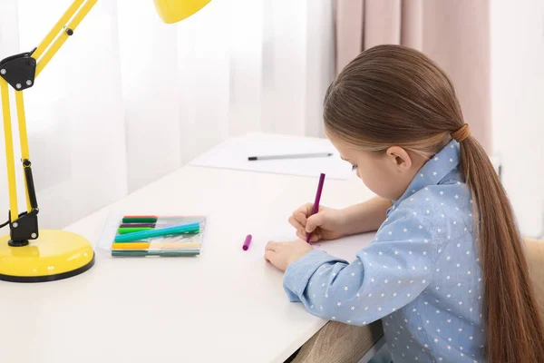 귀엽고 귀여운 소녀가 책상에 마커를 안에서 그림을 그립니다 — 스톡 사진