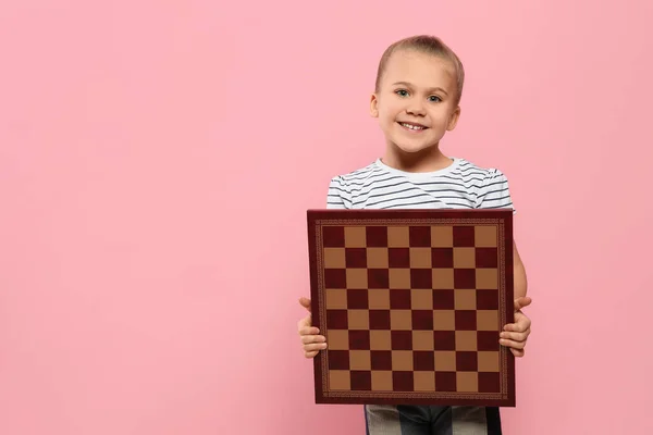 Roztomilá Dívka Drží Šachovnici Růžovém Pozadí Mezera Pro Text — Stock fotografie