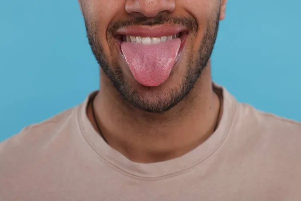 明るい青色の背景に彼の舌を示す幸せな男 クローズアップ — ストック写真