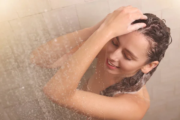 快乐的女人在家里洗澡的时候洗头 — 图库照片