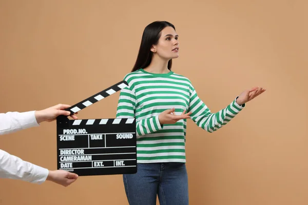 Actrice Treedt Terwijl Tweede Assistent Camera Clapperboard Beige Achtergrond Houdt — Stockfoto