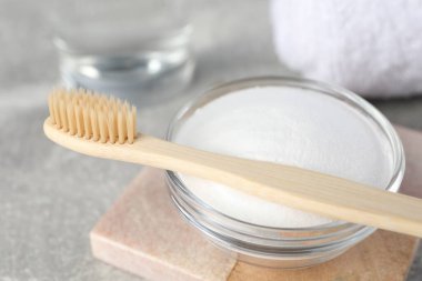 Bambu diş fırçası ve cam kabartma tozu ışık masasında, yakın plan.