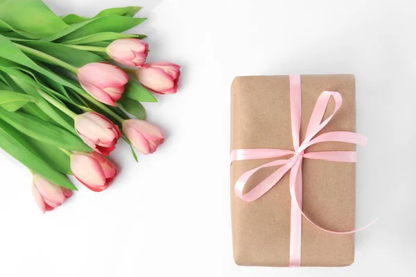 漂亮的礼品盒 白色背景上有蝴蝶结和粉红郁金香 — 图库照片
