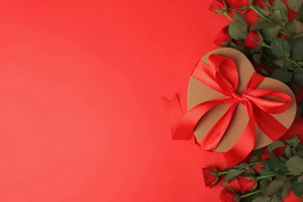 Herzförmige Geschenkschachtel Mit Schleife Und Schönen Rosen Auf Rotem Hintergrund — Stockfoto