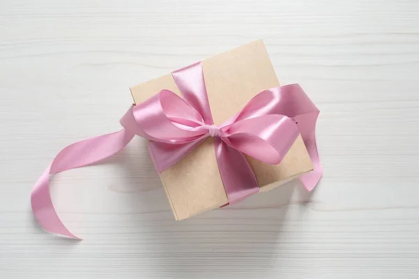漂亮的礼品盒 白色木制背景上有粉色蝴蝶结 顶视图 — 图库照片