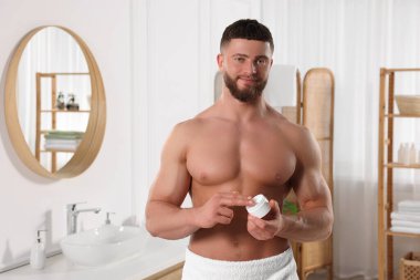 Banyoya vücut kremi süren yakışıklı bir adam. Metin için boşluk