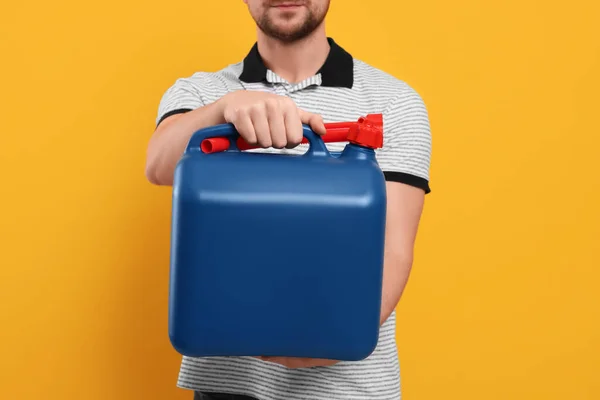 Man Som Håller Blå Behållare Orange Bakgrund Närbild — Stockfoto
