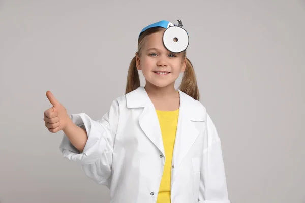 Little Girl Medical Uniform Head Mirror Showing Thumb Light Grey — Stock Photo, Image