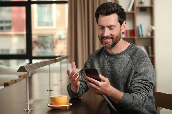 Bonito Homem Enviando Mensagem Smartphone Mesa Dentro Casa — Fotografia de Stock
