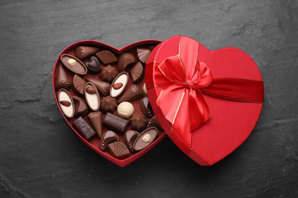Hjärtformad Låda Med Läckra Chokladgodis Svart Bord Ovanifrån — Stockfoto