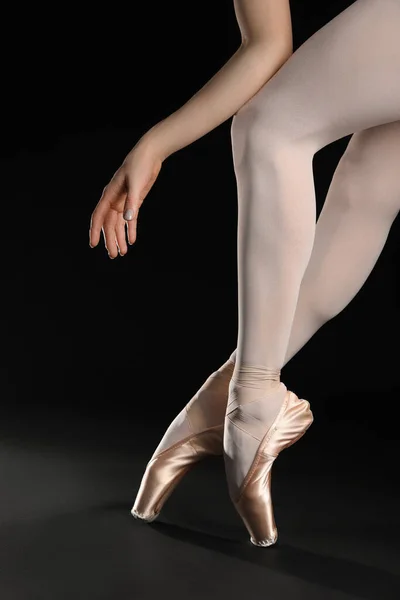 芭蕾舞女演员穿着尖皮鞋 在黑色背景下跳舞 — 图库照片