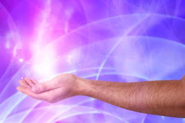 Aura fenomeni. Ellerinin etrafında ışık ve enerji akışı olan bir adam renk arkaplanına karşı, yakın plan