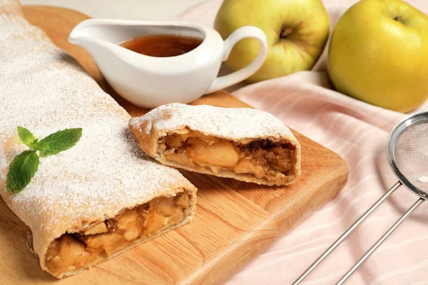 Delicious strudel with apples and nuts served on table, closeup