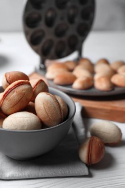 Lezzetli ceviz şekilli kurabiyeler. Yoğunlaştırılmış süt beyaz ahşap masada. Yakın plan.