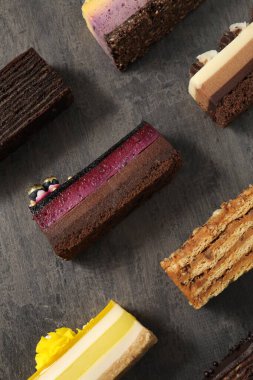Gri masanın üzerinde bir sürü lezzetli pasta, düz bir şekilde.