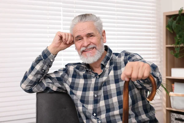 老年人 拿着手杖坐在家里的扶手椅上 — 图库照片