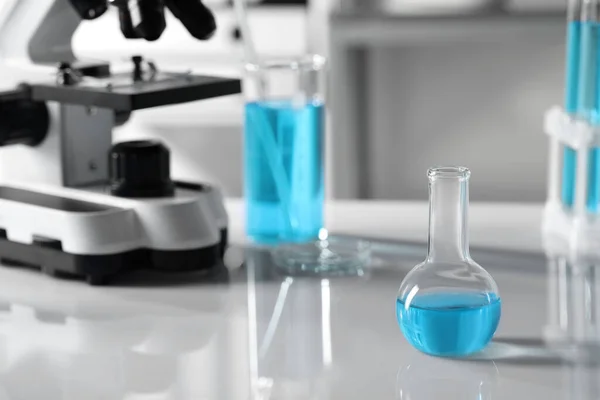 Різний Лабораторний Посуд Світло Блакитною Рідиною Біля Мікроскопа Столі Простір — стокове фото