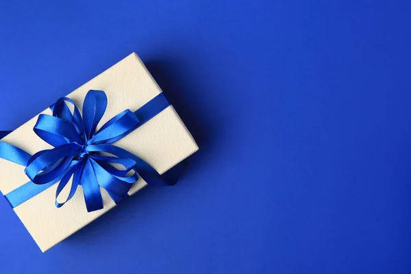 stock image Beautiful gift box with bow on blue background, top view. Space for text