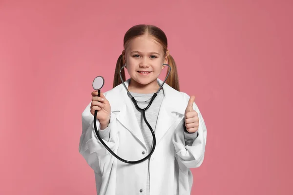 Little Girl Medical Uniform Stethoscope Showing Thumb Pink Background Stock Image
