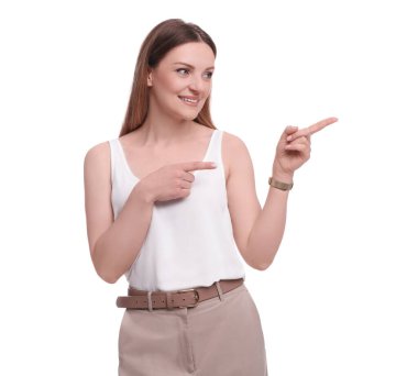 Güzel iş kadını beyaz arka planda bir şeye işaret ediyor.