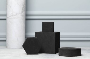 Açık gri masada siyah geometrik şekiller. Ürün için stil sunumu