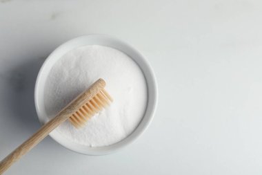 Bambu diş fırçası ve beyaz mermer masada bir kase kabartma tozu, üst manzara. Metin için boşluk