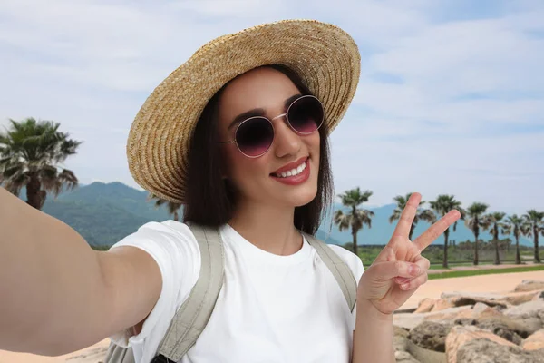 Sorrindo Jovem Mulher Óculos Sol Chapéu Palha Tomando Selfie Mostrando — Fotografia de Stock