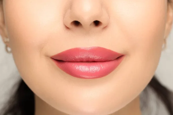 光の背景に光沢のある口紅を持つ女性 クローズアップ — ストック写真